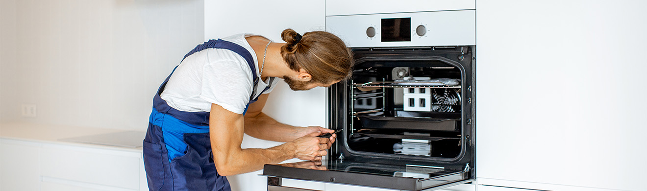 Techniker installiert Elektrobackofen in moderner Küche beim Hausgerätekundendienst in Wiesbaden mit professioneller Reparatur und fachgerechter Montage.