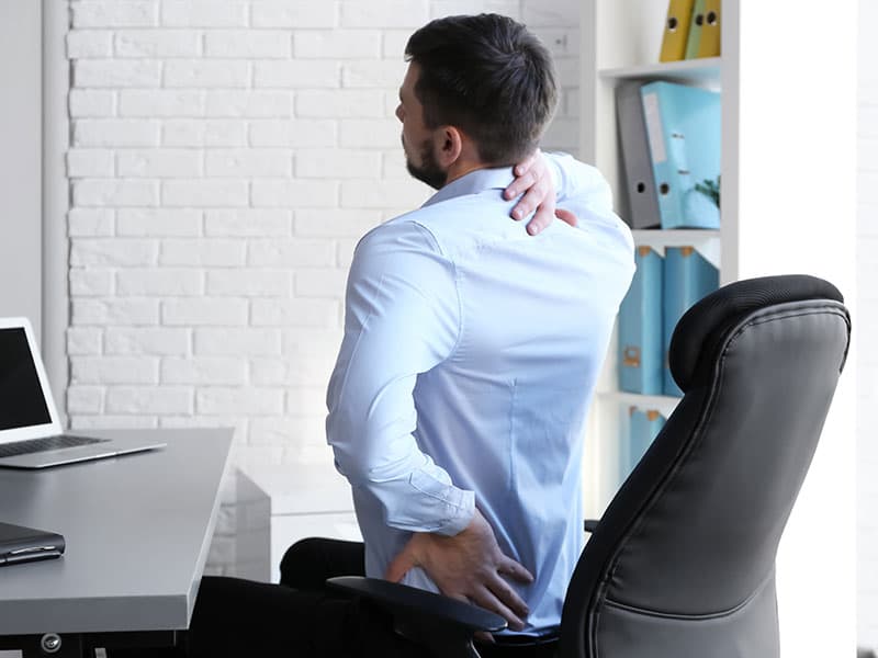 Ein Büroangestellter in Wiesbaden hat starke Rückenschmerzen