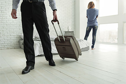 Mann mit Koffer zieht von zu Hause aus und verlässt seine Frau