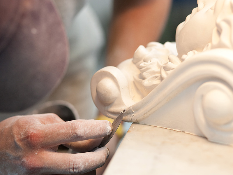 Stuckateur restauriert sorgfältig historische Stuckfigur und führt präzise Stuckrestaurierung in Wiesbaden mit handwerklichem Können und viel Erfahrung aus.